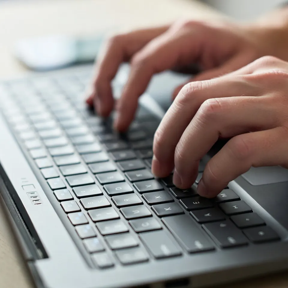 Close-up of hands typing on a keyboard